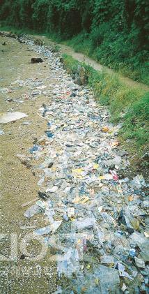 파도에 밀려 해변가에 쌓인 쓰레기 의 사진